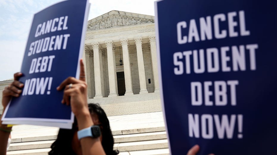 Activists holding up signs during a rally outside the U.S. Supreme Court